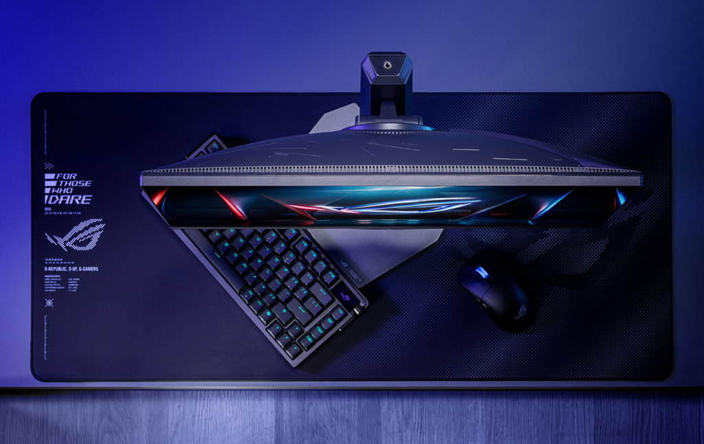 ROG Strix XG248QSG Ace 모니터의 상단과 소형 받침대, 키보드와 마우스가 놓인 데스크