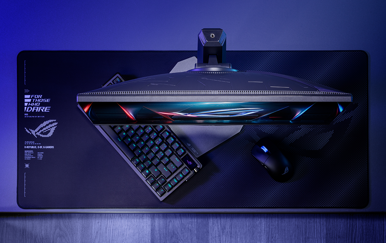 ROG Strix XG248QSG Ace 모니터의 상단과 소형 받침대, 키보드와 마우스가 놓인 데스크